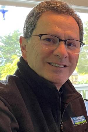 Profile photo of Dean Winick in a black shirt, wearing glasses and nature background